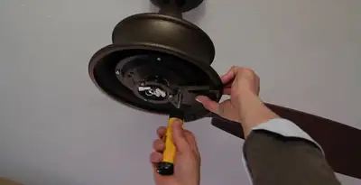 Electrician installing ceiling fan mounting bracket and fixture in San Jose, CA