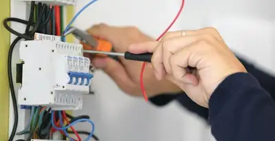 Electrician installing and adjusting circuit breakers in an electrical panel in San Jose, CA