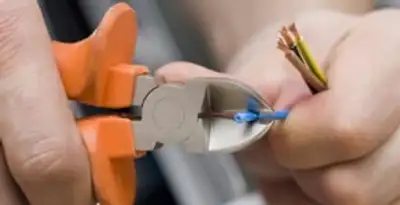 licensed electrician performing precise wire cutting and preparation during electrical service in San Jose, CA