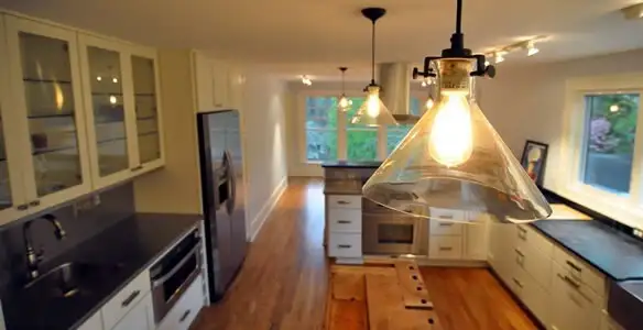 Residential electrician installing modern indoor light fixture in a home in San Jose, CA