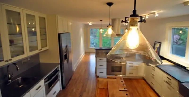 Residential electrician installing modern indoor light fixture in a home in San Jose, CA